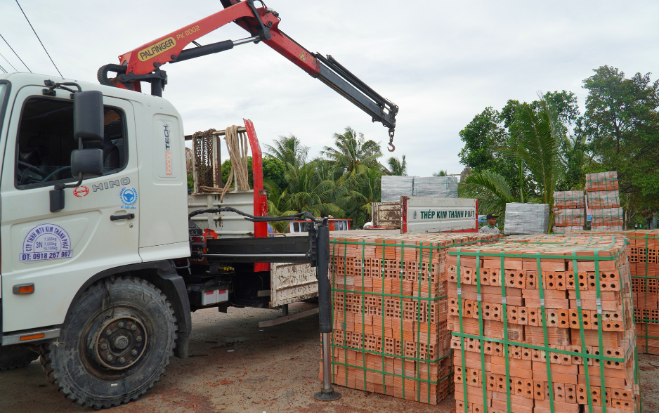 Xe gắn cẩu gập Palfinger tại kho bãi xây dựng.png